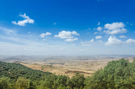 Beautiful view from mountain to valley under blue sky with white cloudsの写真素材