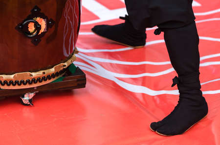 Japanese artist is drumming on traditional taiko drums. Drumsticks beating on a traditional drumの写真素材
