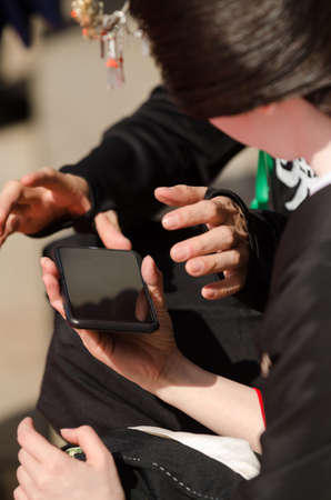 Two japanese friends with smart phone outdoor looking at device