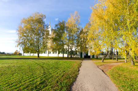 Beautiful autumn road in the Konstantinovo village with Russian church from 18th century and golden trees at background. The place where Esenin russian poet lived - most beautiful place in Rybninskiy Region - Russia, Europeの写真素材