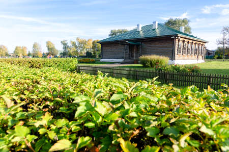 A wooden old brown school in Konstantinovo village with green at foreground from 18th century. The place where Esenin russian poet lived - most beautiful place in Rybninskiy Region - Russia, Europeの写真素材