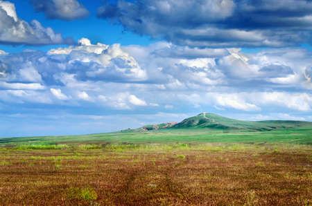 The Bogdo mountain under beautiful sky shoot in May. Spring is beautiful time. Hills are green and covered by emerald grass. Panorama of steppe near salt lake Baskunchak, Russiaの写真素材