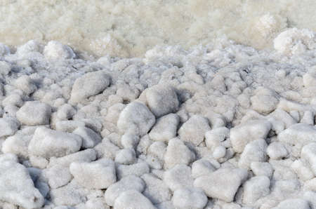 Rocks covered with salt on coast of Baskunchak lake, Russia in sunrays.