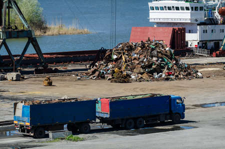 Crane in river port. Heavy cranes unloading metal to import. Steel delivery.の写真素材