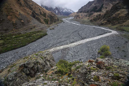 Beautiful view on impressive gorge in Caucasus mountains. Monument in form of Cross and path to it.