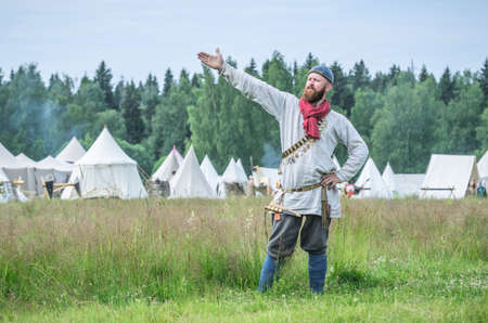 MOSCOW,RUSSIA-June 06,2016: Man in ancient peasant costume stands on green field of grassのeditorial素材