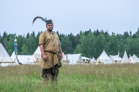 MOSCOW,RUSSIA-June 06,2016: Man in ancient peasant costume stands on green field of grassのeditorial素材