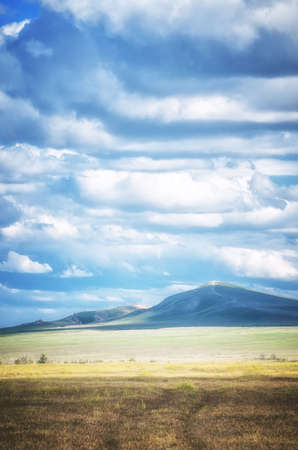 The Bogdo mountain under beautiful sky shoot in May. Spring is beautiful time. Hills are green and covered by emerald grass. Panorama of steppe near salt lake Baskunchak, Russiaの写真素材