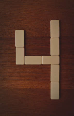 number four laid out the domino chips on a wooden tableの写真素材