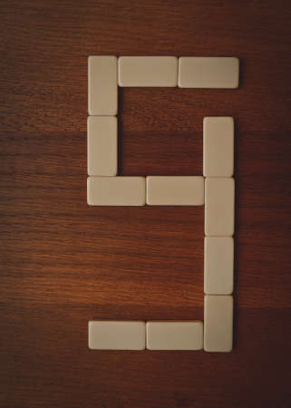 number nine laid out the domino chips on a wooden tableの写真素材