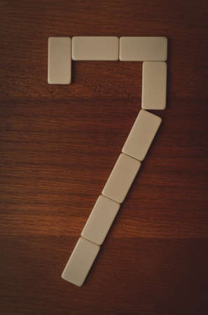 number seven laid out the domino chips on a wooden tableの写真素材