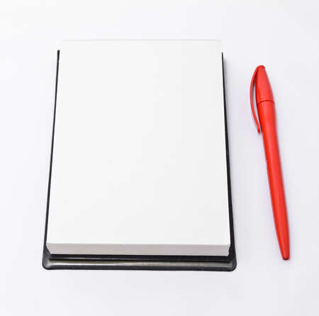 Open notepad and a red pen isolated on white backgroundの写真素材