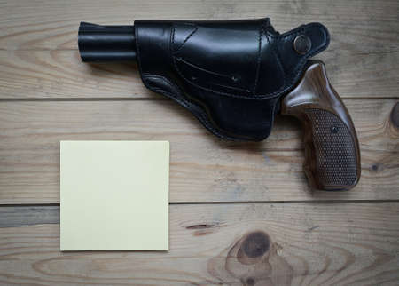 revolver in a holster on a wooden table