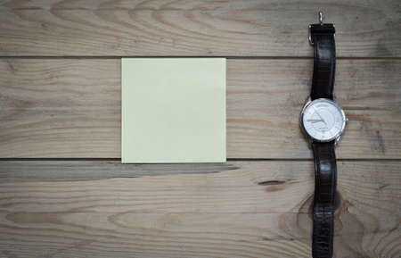 notepad and clock on the wooden tableの写真素材