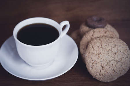 fresh cup of coffee and biscuits for breakfast on a wooden tableの写真素材