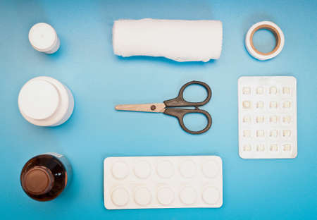 medical kit: scissors, bandages, pills on a blue backgroundの写真素材