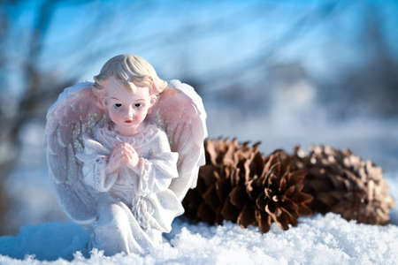 little christmas angel in the snow and blue skyの写真素材