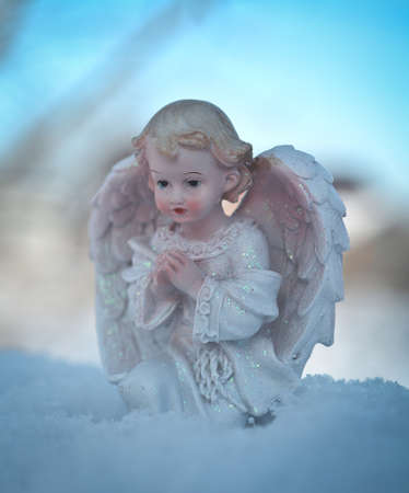 Guardian angel on blue sky background. Religion and faith concept. Winter time.の写真素材