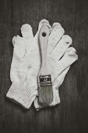 Paint roller brushes working gloves on wooden board construction concept.の写真素材