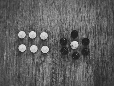 white king surrounded by black pawnsの写真素材