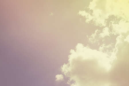 Bright sun on blue sky with white fluffy clouds, background.の写真素材