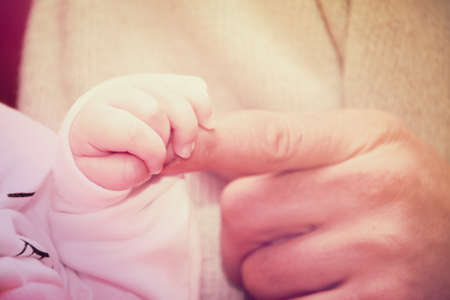 Newborn baby holding mothers hand, image with shallow depth of fieldの写真素材