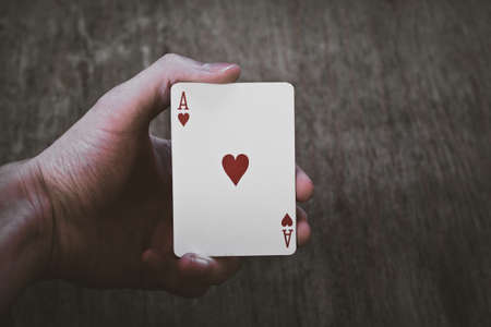 Man holding ace of hearts in hands isolatedの写真素材