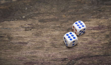 Two game dice on the wooden table number sixの写真素材