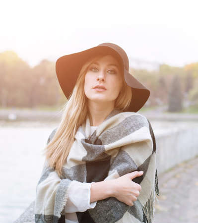 Portrait of a serious and elegant beautiful white girl in a black hat