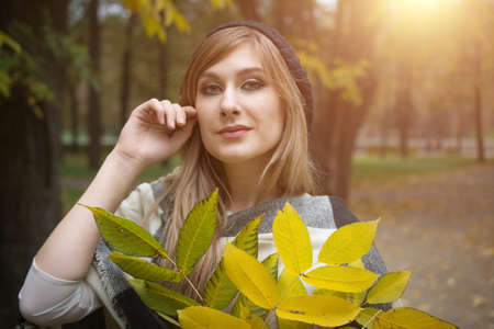 Portrait of smiling young woman with autumn leafs
