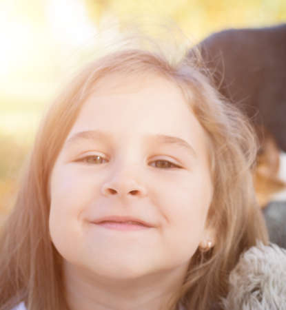 Close up portrait of cute little girl in autumn park