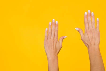 Woman hands over yellow background with copyspaceの写真素材