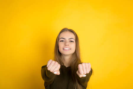 portrait of the beautiful young woman on the yellow background wall, copyspaceの写真素材
