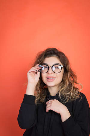 portrait of a beautiful smart and stylish girl on a red background