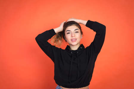 lovely young girl posing in the studio on a red background