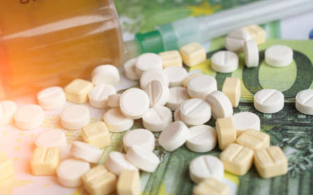 Pills and one hundred euro banknote close up