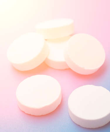 White pills close up over blue backgroundの写真素材
