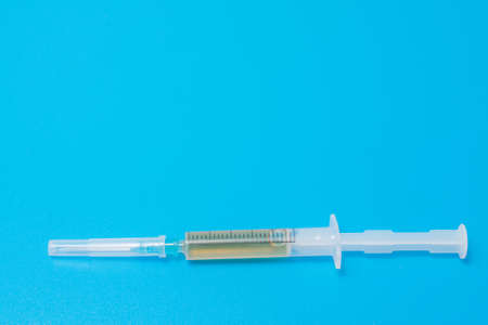 small drug syringe on a blue backgroundの写真素材