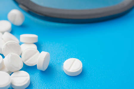 White pills abstract on a blue background, studio shotの写真素材