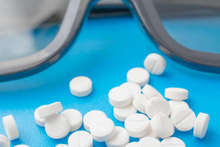 White pills abstract on a blue background, studio shotの写真素材