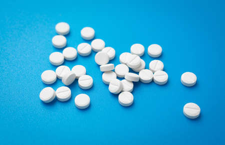 White pills abstract on a blue background