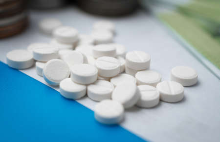 Pharmaceutical business abstract, white pills on a blue backgroundの写真素材
