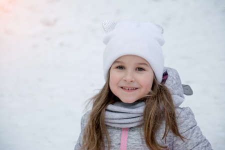 portrait of a beautiful little girl of 6 years in the winter park