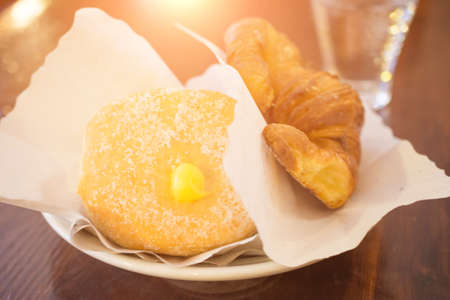 delicious donut for breakfast in an italian bar, Croissant and donut on white dish in lounge bar,...