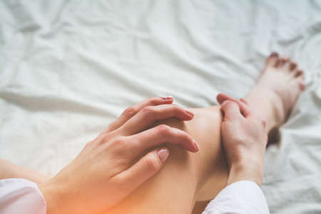 Two sexy woman legs with hands in bed, love abstractの写真素材