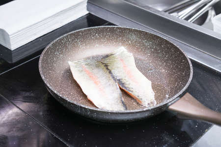 frying fish in a skillet