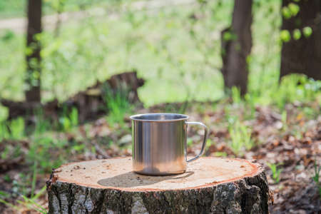 Metal mug on background of forestの写真素材