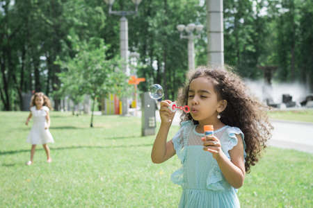 A little girl blowing soap bubblesの写真素材