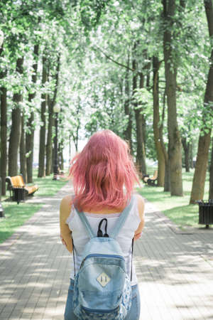 Back view of a hipster girl walking on city streetの写真素材