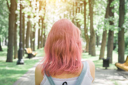 Back view of a hipster girl walking on city streetの写真素材